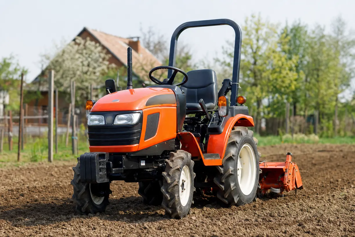 Mini traktor w akcji z osprzętem do koszenia i odśnieżania